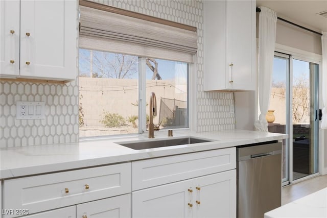 kitchen featuring visible vents, backsplash, dishwasher, white cabinetry, and a sink