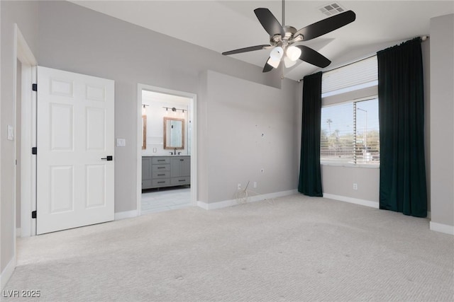 unfurnished bedroom with visible vents, connected bathroom, baseboards, carpet, and a ceiling fan