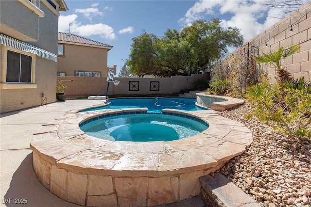 view of pool with a fenced backyard and a pool with connected hot tub