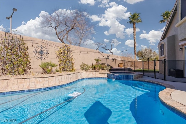 view of pool with a fenced backyard and a pool with connected hot tub