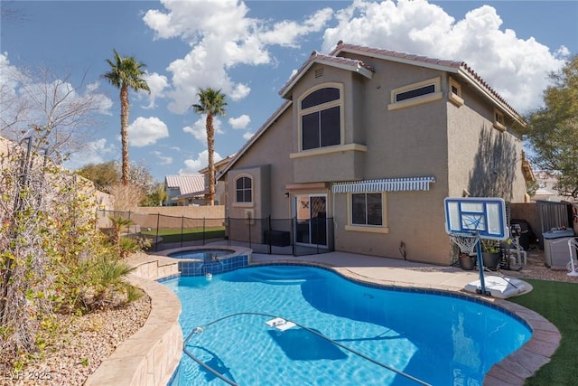 view of swimming pool featuring a patio, a fenced backyard, and a pool with connected hot tub