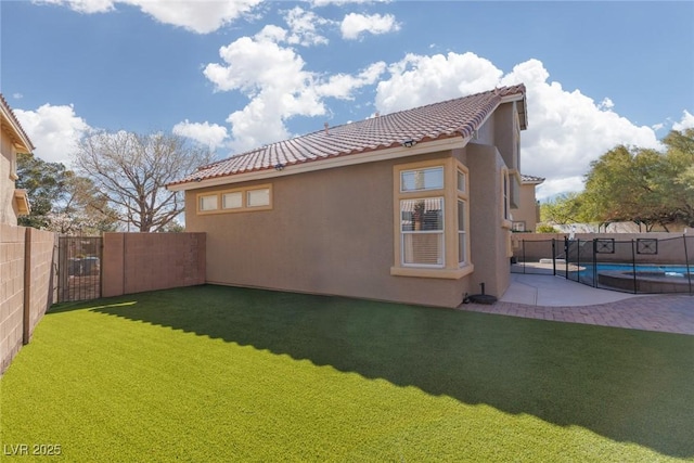 rear view of property featuring stucco siding, a yard, a fenced in pool, and a fenced backyard