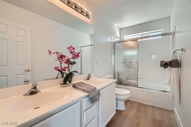 full bathroom featuring double vanity, toilet, wood finished floors, and a sink