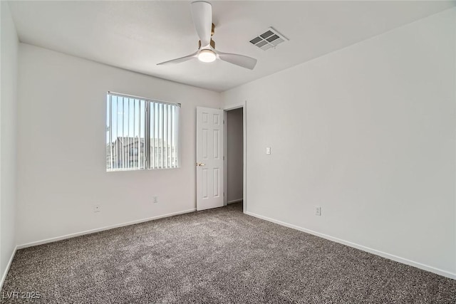 carpeted spare room with baseboards, visible vents, and ceiling fan