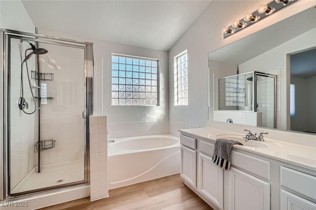 bathroom featuring vanity, a bath, wood finished floors, and a stall shower