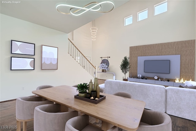 living room with a high ceiling, wood finished floors, and stairs