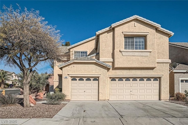 view of front of property featuring stucco siding, a garage, concrete driveway, and a tiled roof