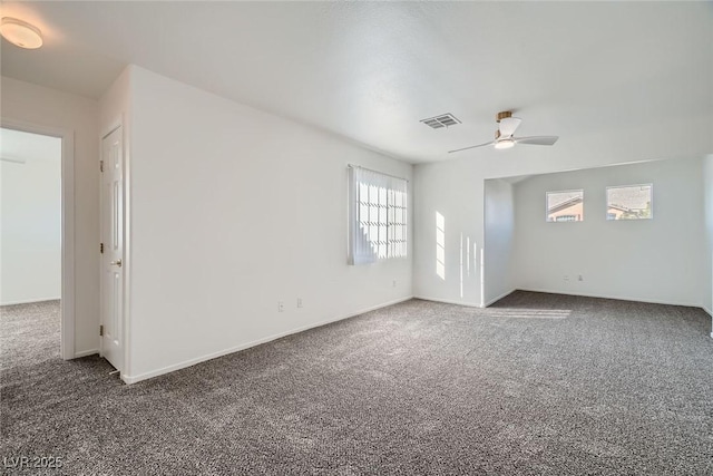 spare room with visible vents, carpet floors, baseboards, and ceiling fan