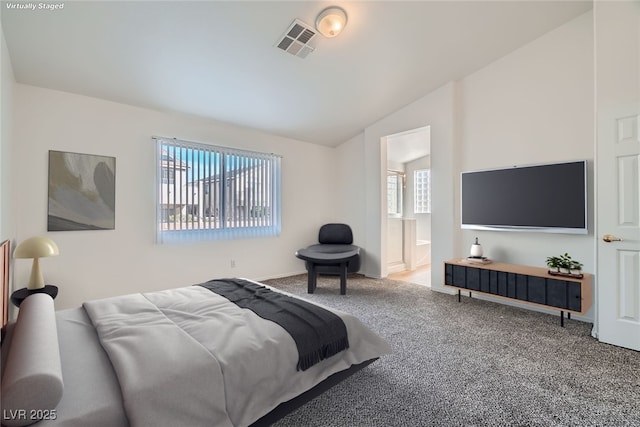 carpeted bedroom featuring vaulted ceiling, visible vents, and connected bathroom