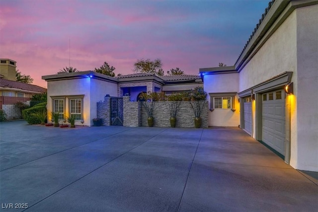 exterior space featuring stucco siding, a tile roof, driveway, and fence