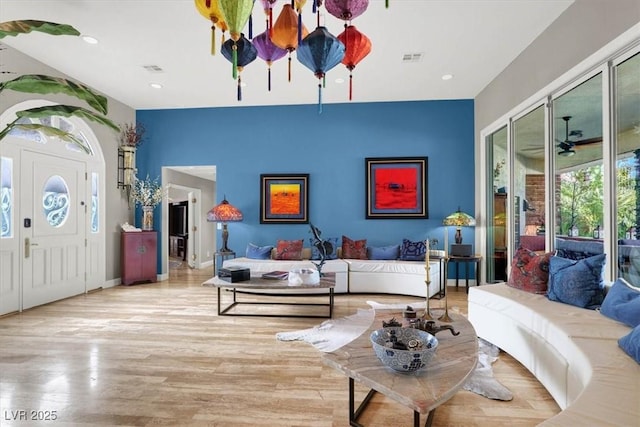 living area featuring recessed lighting, visible vents, baseboards, and wood finished floors