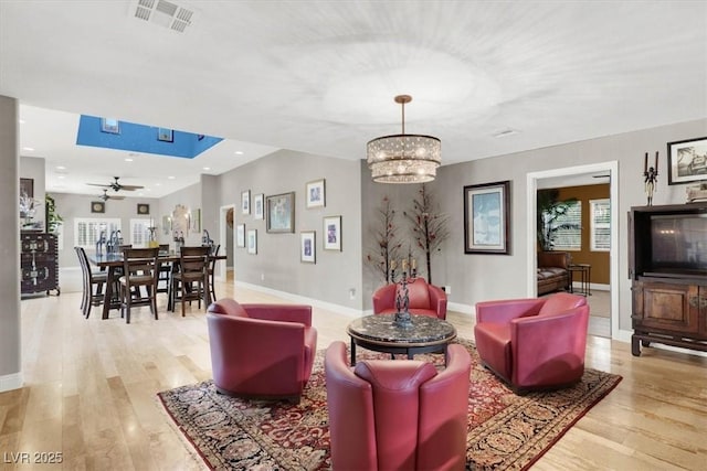 living area with visible vents, baseboards, a healthy amount of sunlight, and light wood-style flooring