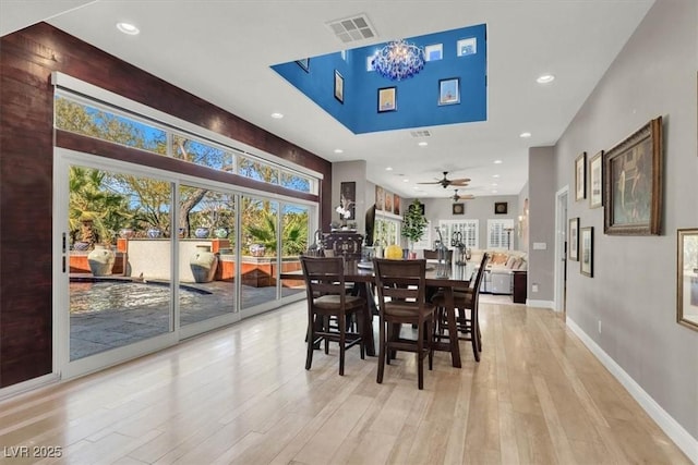 dining room featuring baseboards, visible vents, light wood finished floors, recessed lighting, and ceiling fan with notable chandelier