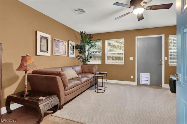 living room with visible vents, baseboards, light carpet, and ceiling fan