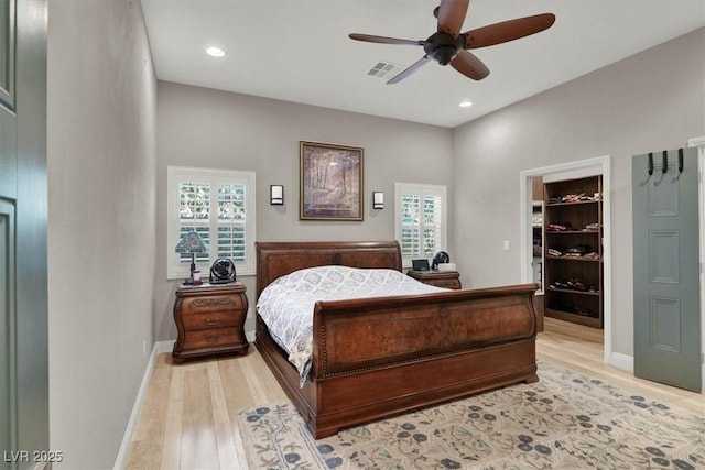 bedroom featuring baseboards, visible vents, light wood-style flooring, recessed lighting, and a spacious closet