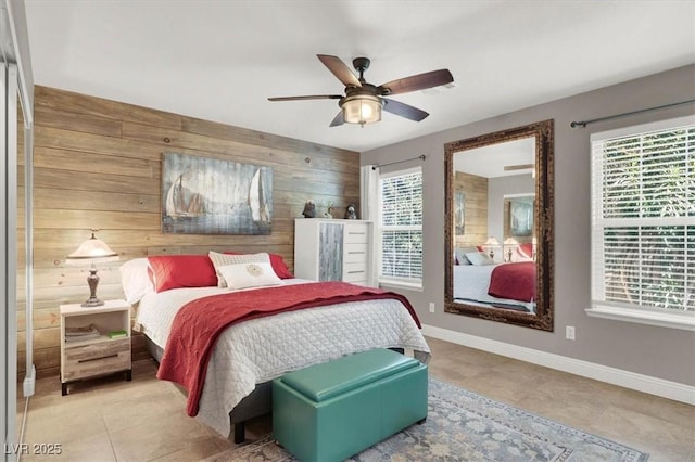 bedroom featuring baseboards, multiple windows, and wood walls