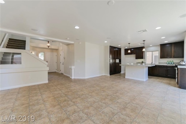 unfurnished living room with visible vents, recessed lighting, and baseboards