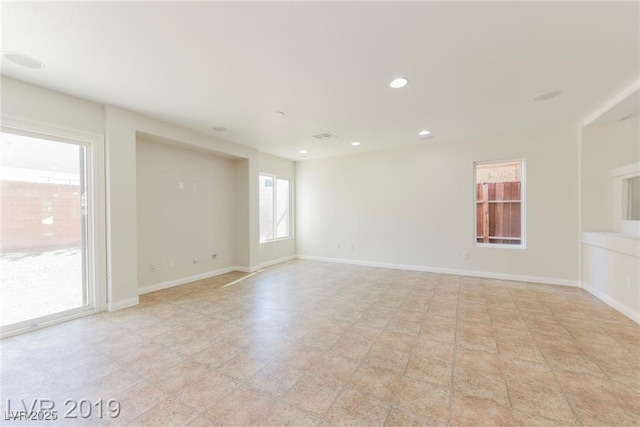 unfurnished room with recessed lighting and baseboards