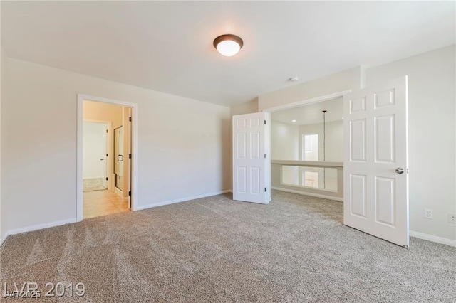 unfurnished bedroom featuring carpet flooring and baseboards