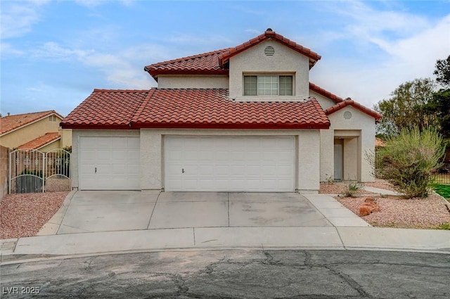 mediterranean / spanish home with fence, stucco siding, concrete driveway, a garage, and a tiled roof