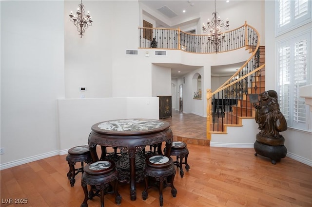 dining space with wood finished floors, a chandelier, and stairs