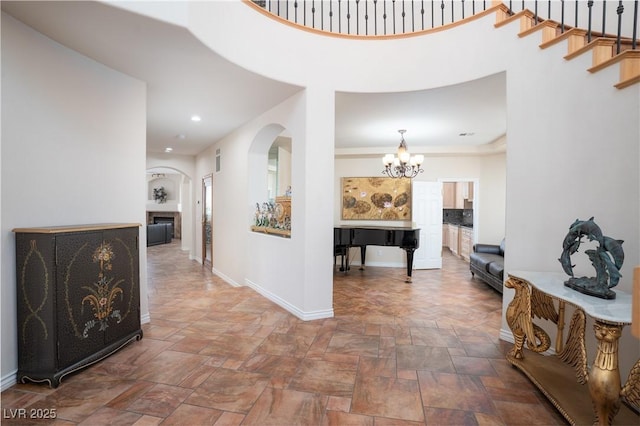 corridor featuring recessed lighting, baseboards, a chandelier, and stone finish floor