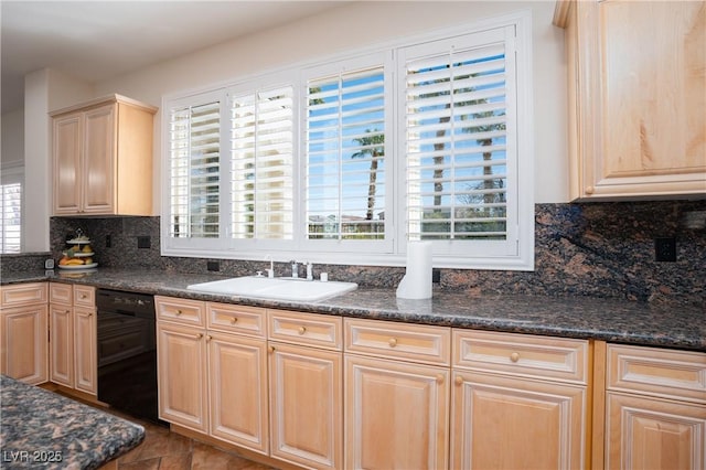 kitchen featuring dark stone counters, light brown cabinetry, a sink, black dishwasher, and backsplash