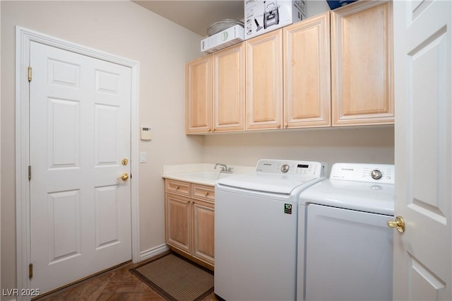 clothes washing area with a sink, cabinet space, and washer and clothes dryer