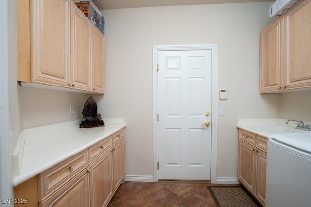 laundry room featuring a sink, baseboards, and washer / clothes dryer