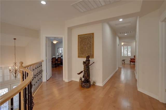 hallway with light wood-type flooring, visible vents, an inviting chandelier, and recessed lighting