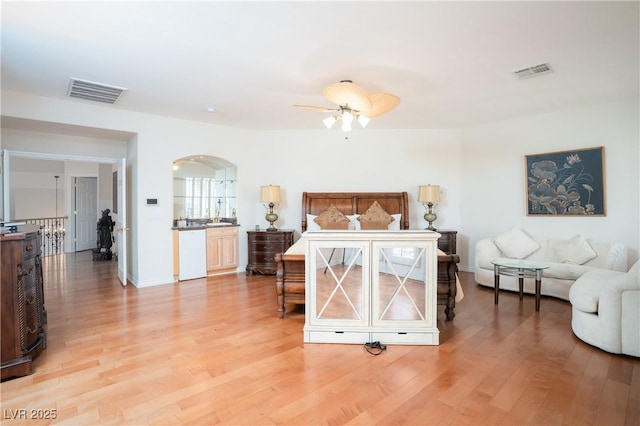 bedroom featuring visible vents, arched walkways, baseboards, and light wood finished floors