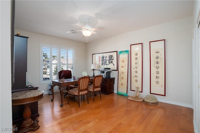 home office with light wood-style flooring, baseboards, and ceiling fan