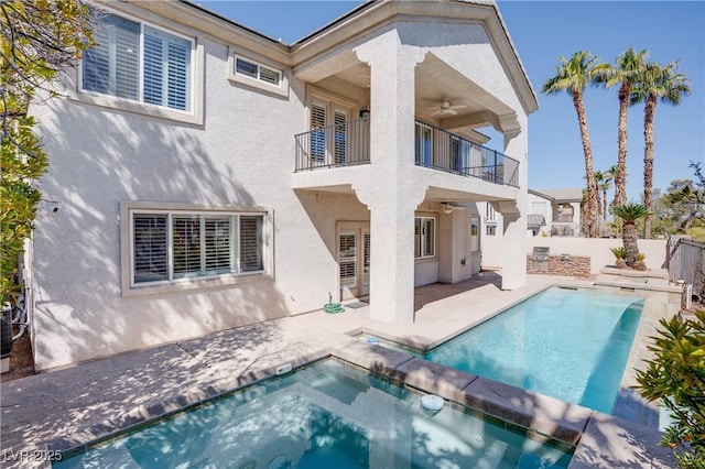 back of house with a balcony, a ceiling fan, a fenced backyard, stucco siding, and a patio area