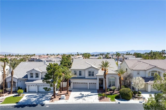 mediterranean / spanish home with concrete driveway, a tiled roof, an attached garage, and a residential view