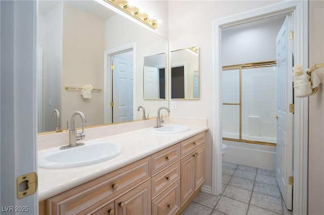 bathroom featuring double vanity, tile patterned floors, enclosed tub / shower combo, and a sink