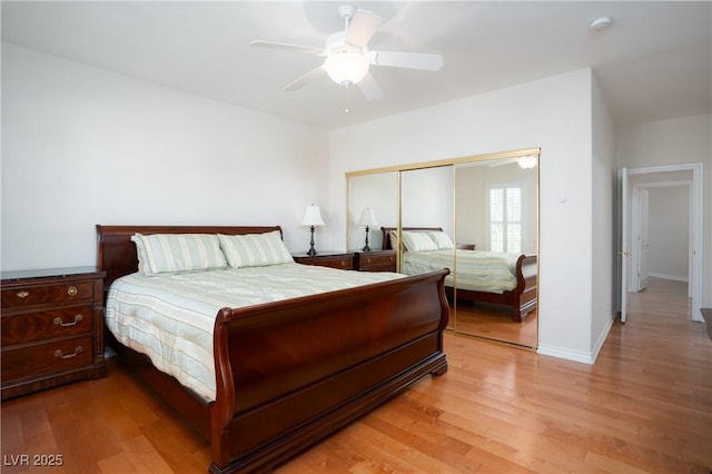 bedroom featuring a closet, light wood-style flooring, a ceiling fan, and baseboards