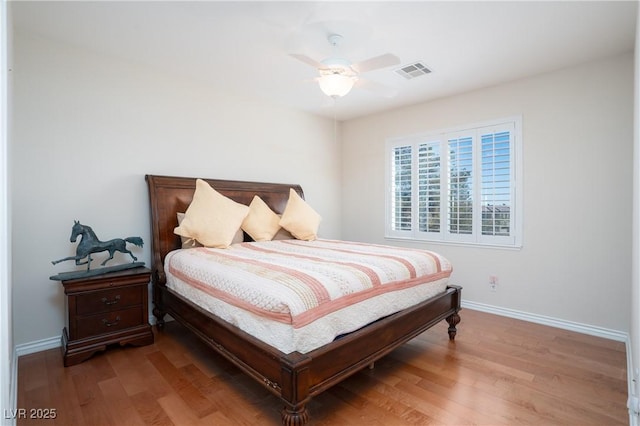 bedroom featuring visible vents, baseboards, and wood finished floors