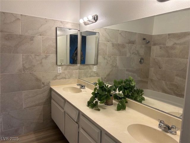 bathroom featuring double vanity, tile walls, and a sink