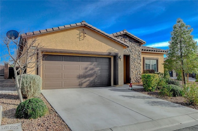 mediterranean / spanish-style home featuring driveway, an attached garage, stucco siding, stone siding, and a tile roof