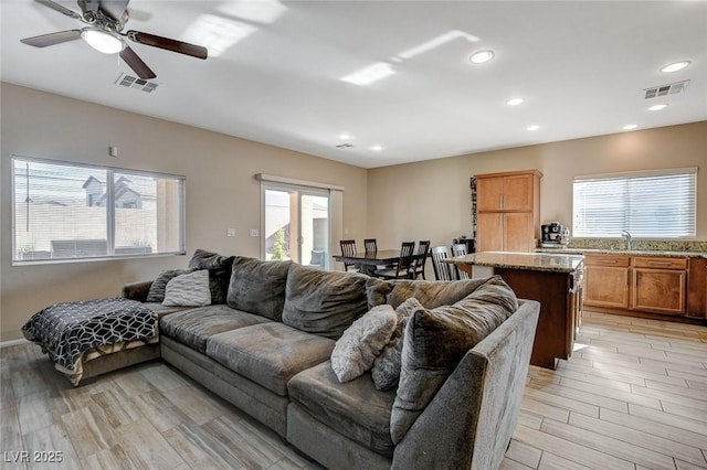 living area with recessed lighting, visible vents, and light wood-style flooring