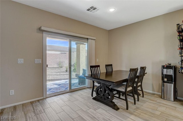 dining space with visible vents, baseboards, and light wood-style flooring