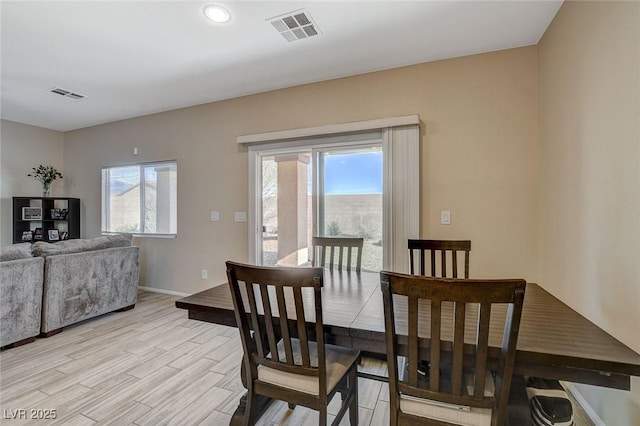 dining area with visible vents, light wood-type flooring, and baseboards