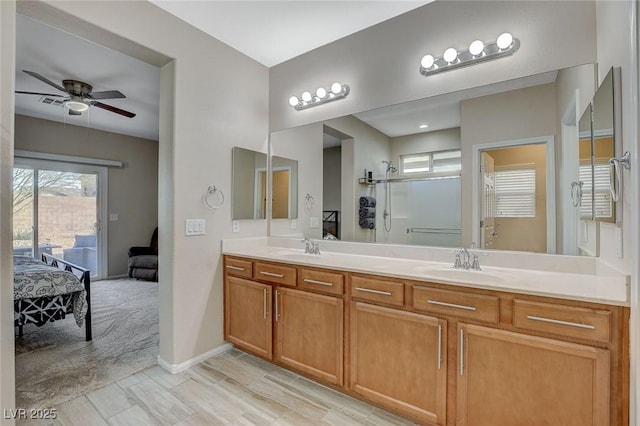 ensuite bathroom featuring ceiling fan, ensuite bath, double vanity, and a sink