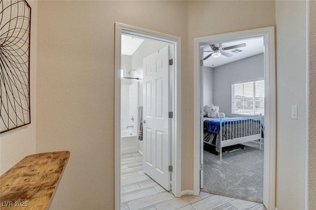 hallway with visible vents and light carpet