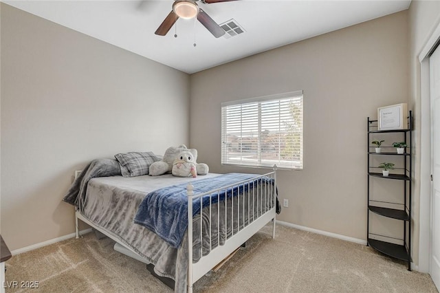 bedroom featuring visible vents, light colored carpet, and baseboards