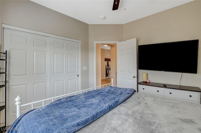 carpeted bedroom with a ceiling fan and a closet