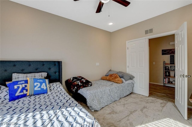 carpeted bedroom with visible vents and a ceiling fan