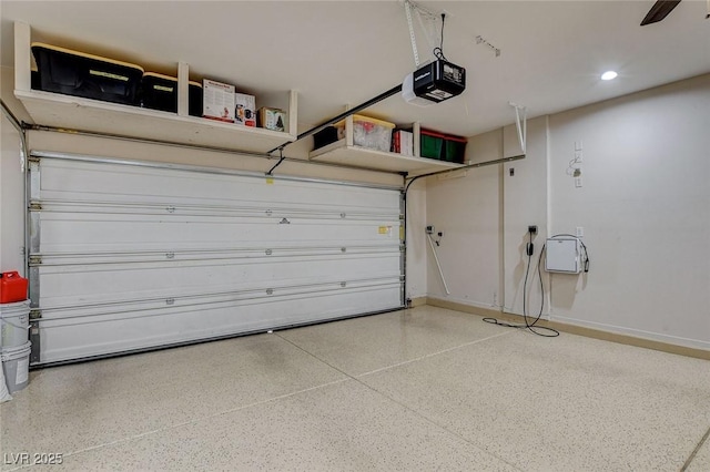 garage featuring a garage door opener and baseboards