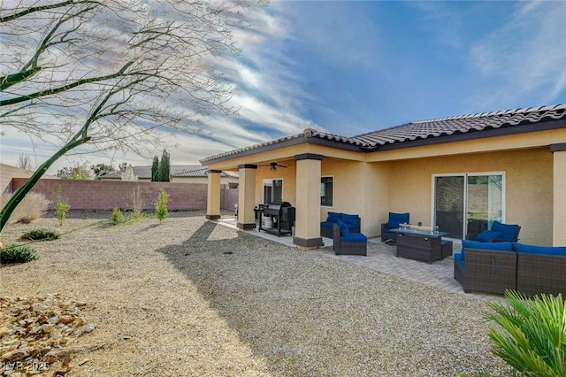 back of house with stucco siding, an outdoor living space, fence, ceiling fan, and a patio area