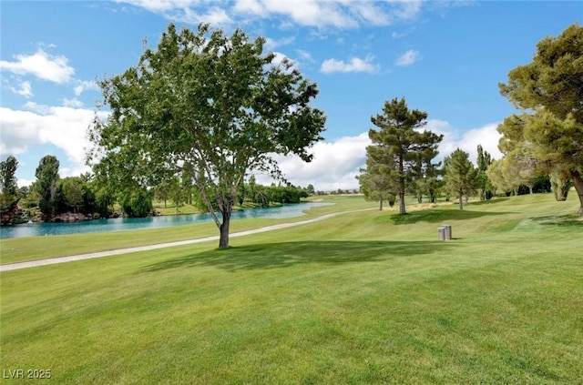 view of property's community featuring view of golf course, a yard, and a water view